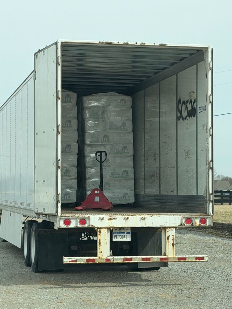 Full truckload of pine shavings pallets in a semi trailer with a pallet jack
